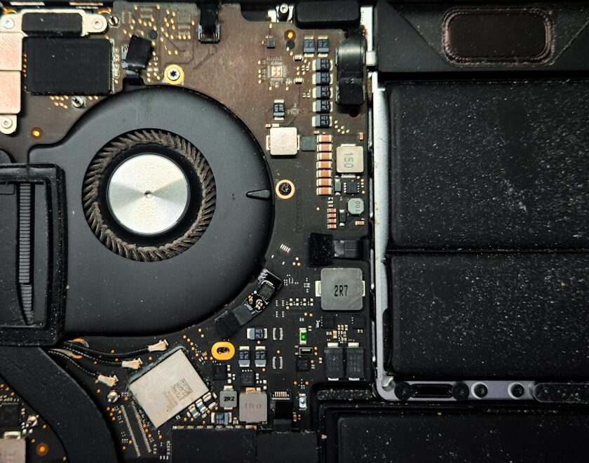 laptop overheating repair tips cover showing a dusty notebook, cooling fan, thermal paste tube, and airflow arrows